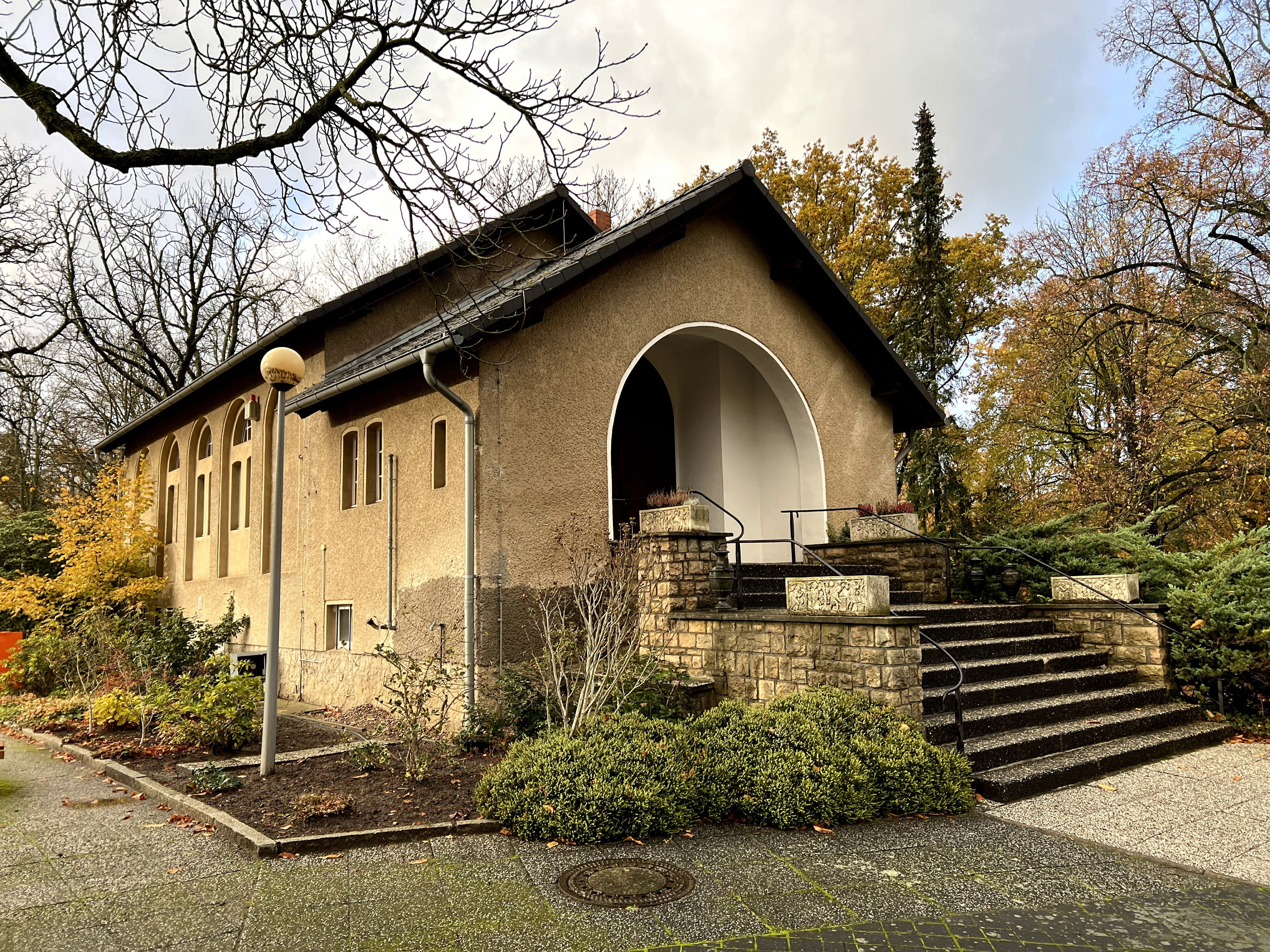 Feierhalle des Parkfriedhofs Marzahn zwischen herbstlichen Bäumen